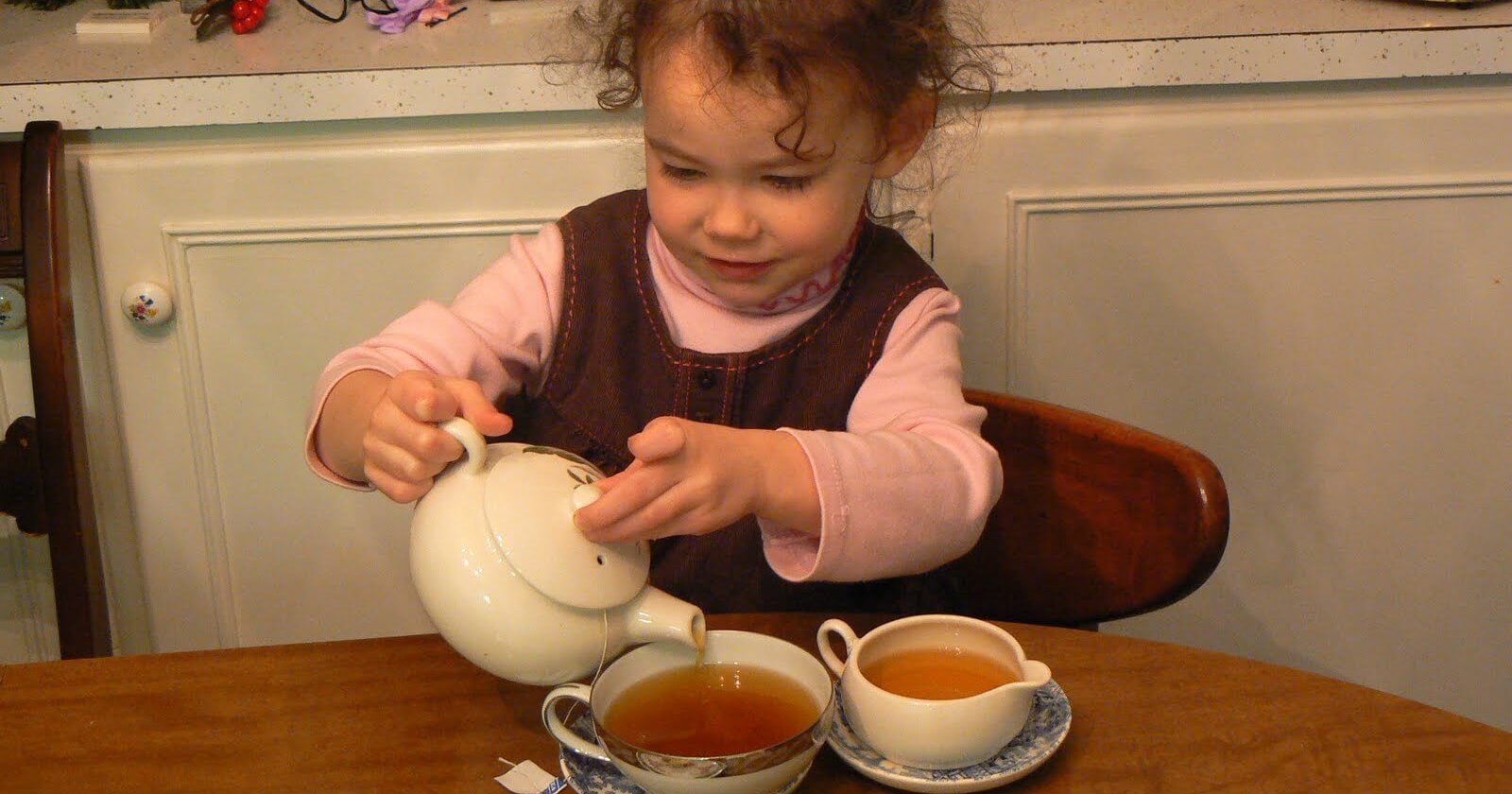 Ребенок наливает чай